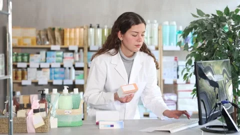 Female pharmacist working at computer in pharmacy Stock Footage 329540196