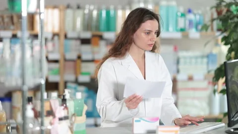 Female pharmacist working at computer in pharmacy Stock Footage 330040054