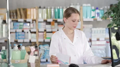 Female pharmacist working at computer in pharmacy Stock Footage 332636253