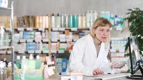 Female pharmacist working at computer in pharmacy Stock Footage 332737091