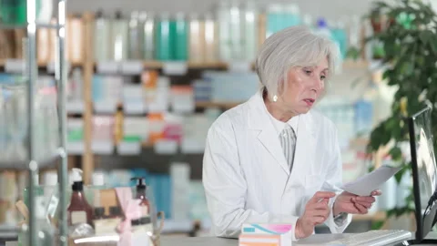 Female pharmacist working at computer in pharmacy Stock Footage 332739112