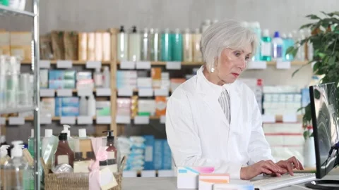 Female pharmacist working at computer in pharmacy Stock Footage 341525094