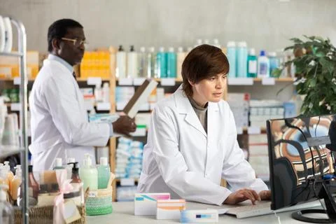 Female pharmacist working at computer in pharmacy Stock Photos