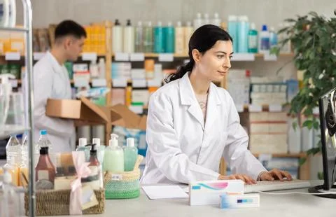 Female pharmacist working at computer in pharmacy Foto stock