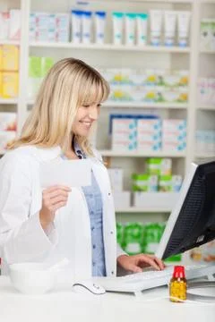 Female pharmacist working on computer Stock Photos