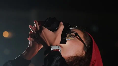 Female photographer methodically captures celestial images during nighttime Stock Footage 328054957