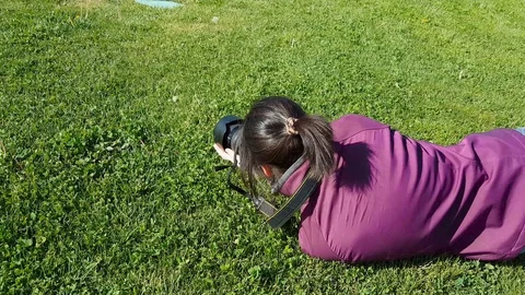 Female photographer using DSLR camera on grass Stock Footage 92692082