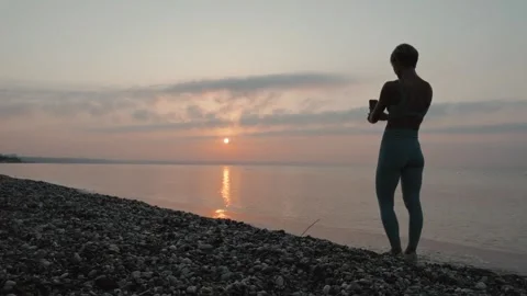 A female photographs a seascape at sunse... | Stock Video | Pond5