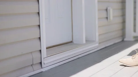 A female picks up a package from outside his front door Stock Footage 92707175