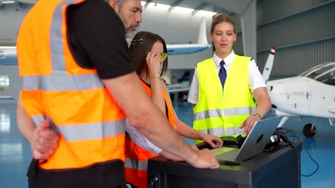 Female pilot instructor training aviation technicians in an aircraft hangar Stock Footage 336380227
