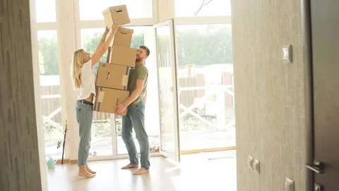 Female placing moving boxes on large stack man is holding all Stock Footage 98450899