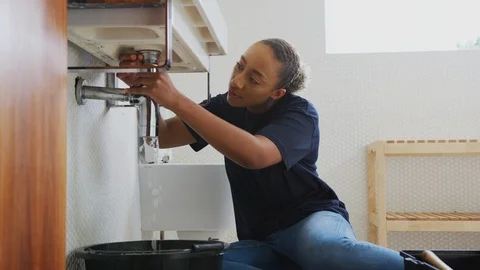 Female Plumber Working To Fix Leaking Sink In Home Bathroom Stock Footage 124569407