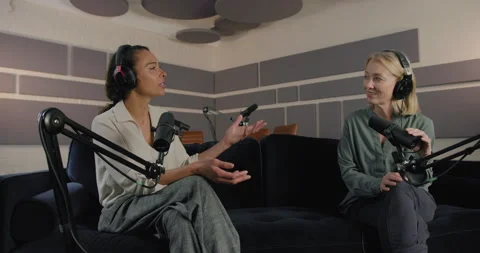 Female Podcaster on Sofa in Studio Interviewing Business woman, wearing Stock Footage 291854613