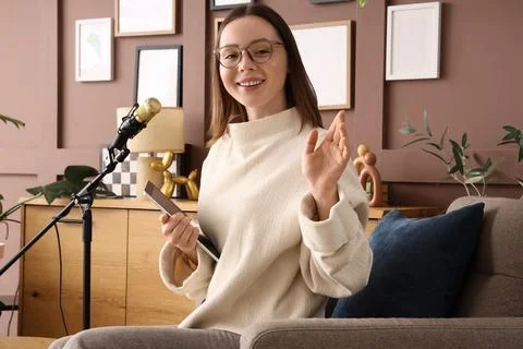 Female podcaster with tablet computer sitting in studio 库存照片