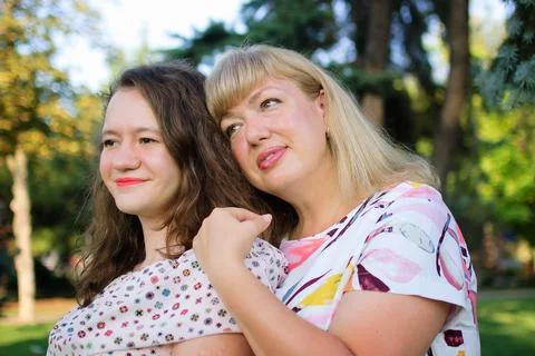 Female portrait of a beautiful plus size blond, blue-eyed mother and daughter in Stock Photos