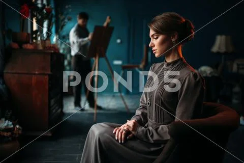 Female poseur, painter against easel on background Stock Photos