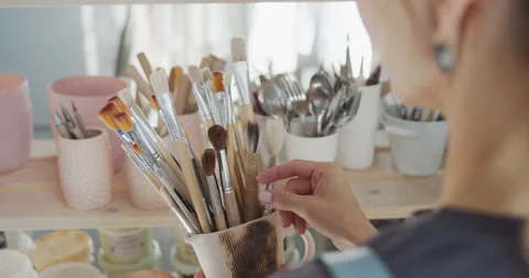 Female potter chooses a brush. Stock Footage 131007953