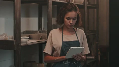 Female Potter Posing with Tablet by Rack Stock Footage 169859590