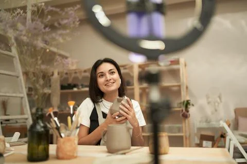 Female potter recording tutorial in workshop 库存照片