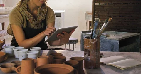Female potter using digital tablet while working Stock Footage 70595094