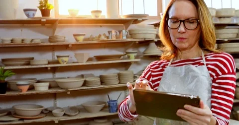 Female potter using digital tablet 4k Stock Footage 85324300