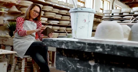 Female potter using digital tablet 4k Stock Footage 85324379