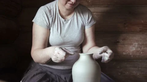 Female potter using a thread while working with clay on a pottery wheel Stock Footage 132041067