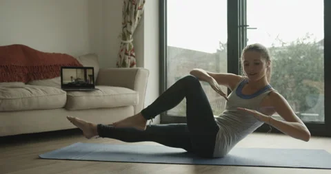 Female practicing pilates exercise at home watching video tutorial on laptop Vídeos de archivo 141843780