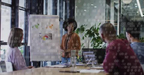Female presenter in brown blouse explaining data in conference room, with flip Stock Photos