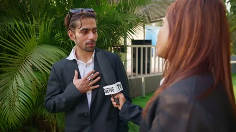 Female presenter lifts mic while leader responds outdoor Stock Footage 304849152