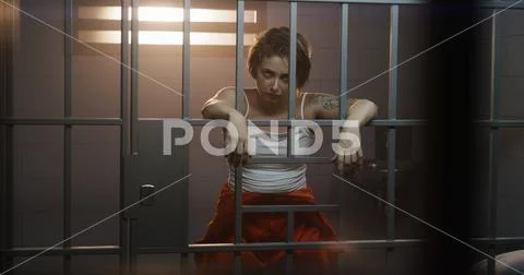 Photograph: Female prisoner stands in jail cell, looks at camera #246427257