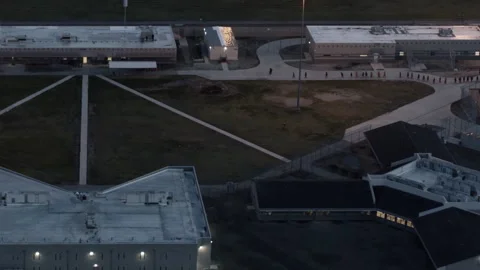 Female prisoners lining up in the prison yard at dusk Stock Footage 331602467