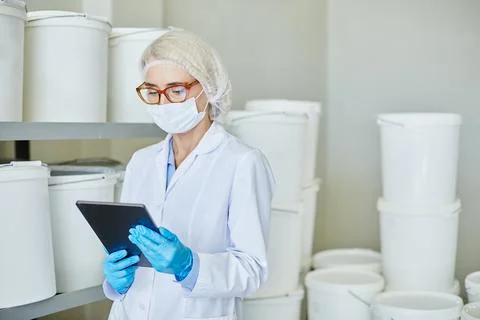Female Process Technician Using Tablet to Take Inventory in Stockroom with 写真素材