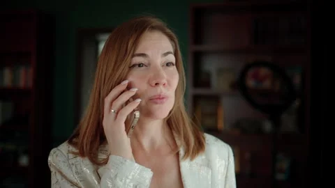 Female professional engages in a conversation using her phone Stock Footage 348083022