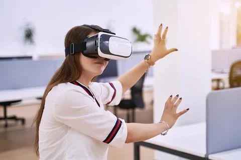 Female professional using vr virtual reality headset at desk in office Stock Photos