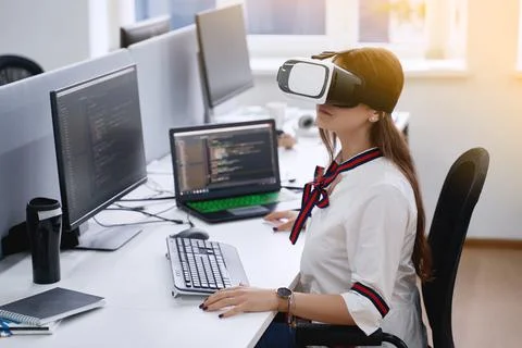 Female professional using vr virtual reality headset at desk in office Stock Photos