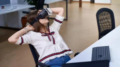 Female professional using vr virtual reality headset at desk in office Stock Photos