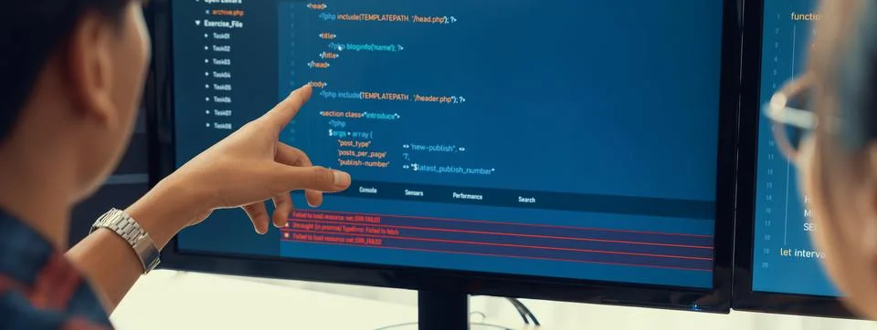 Female programer explain while pointing code displayed on computer. Burgeoning. Foto stock