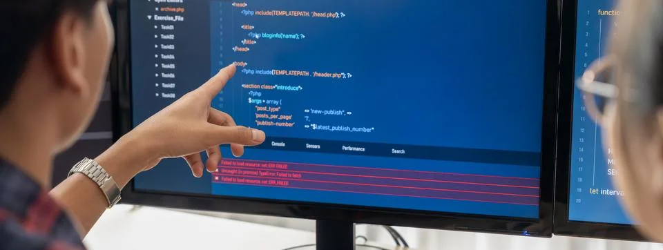 Female programer explain while pointing code displayed on computer. Burgeoning. 库存照片