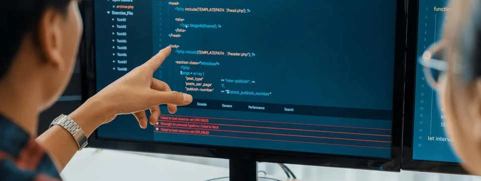 Female programer explain while pointing code displayed on computer. Burgeoning. Stock Photos