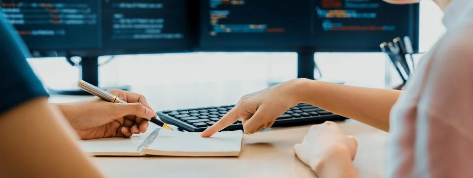 Female programer taking a note while web developer present program. Burgeoning. Stockfoto's