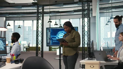 Female programmer coding AI algorithms on tablet to debug software issues Stock Footage 313165723