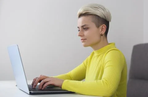 Female programmer coding on computer at home. Young white woman with short .. Foto stock