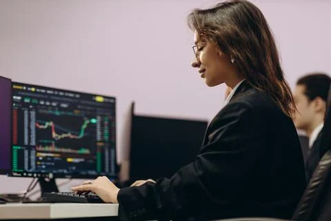 Female programmer coding in the office. Side view of a woman working as a web Stock Photos