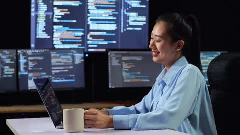 Female Programmer Drinking Coffee  Writing Code Laptop Using Multiple Monitors Stock Footage 244426799