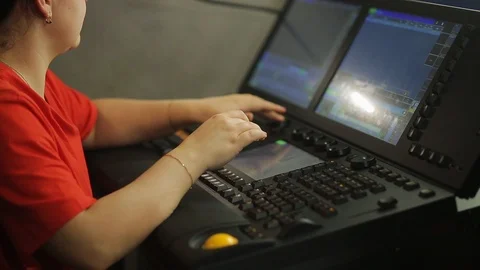 A female programmer illuminator at the remote control programs the stage light Stock Footage 126236792