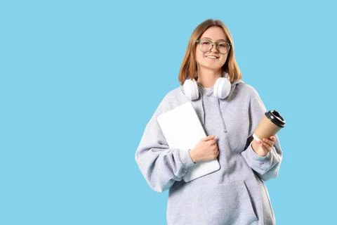 Female programmer with laptop, cup of coffee and headphones on blue backgroun Stock-Fotos