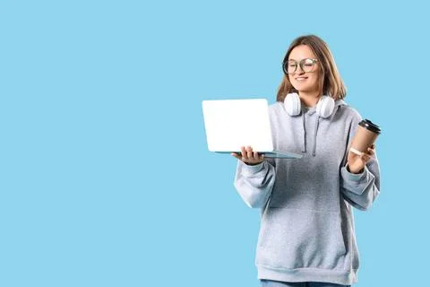 Female programmer with laptop, cup of coffee and headphones on blue backgroun Stock-Fotos