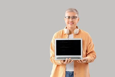 Female programmer with laptop on light background Stock Photos