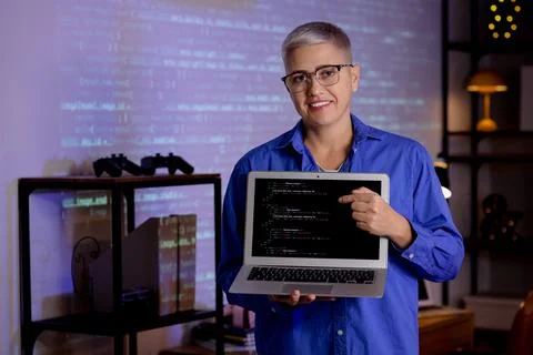 Female programmer with laptop in office at night Stock-Fotos